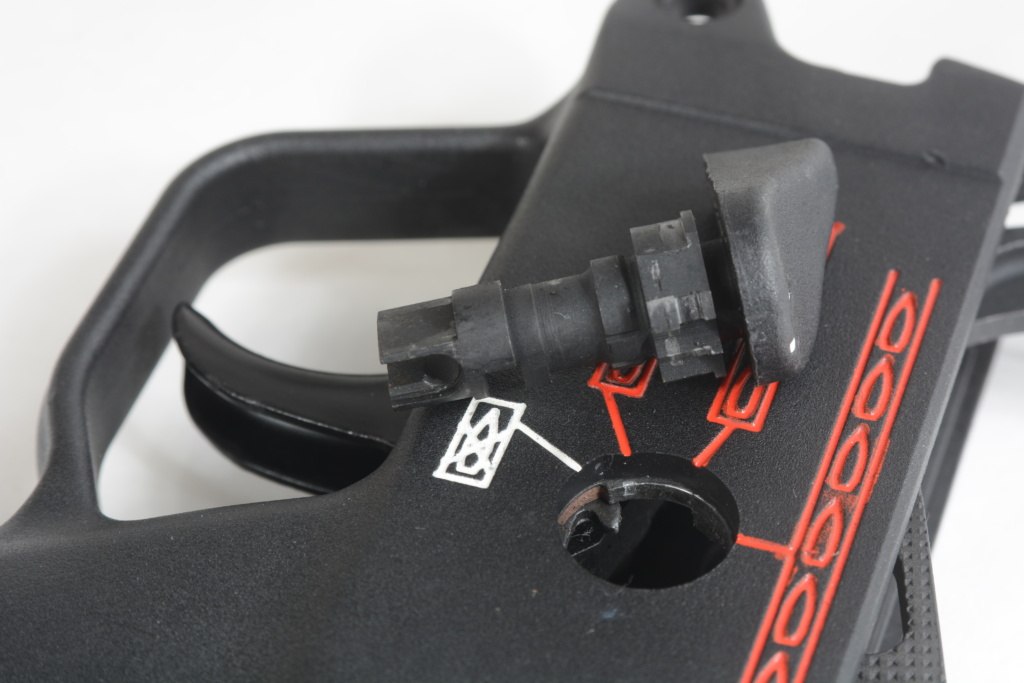 Removing the trigger pack from the housing starts with the selector. In the four-position style used on the AP53, a pointed tab (visible inside the hole at 11 o’clock) holds the left side selector lever in place.
